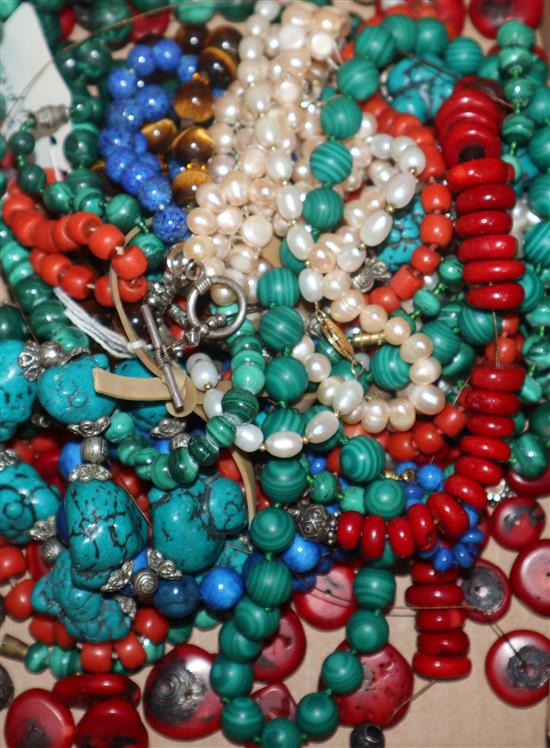 Fourteen assorted ethnic and other bead necklaces including coral, malachite and tigers eye quartz.